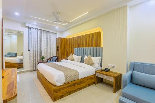 a bedroom with a large bed and a blue couch at Hotel K K Casa Near New Delhi Railway Station & Connaught place in New Delhi