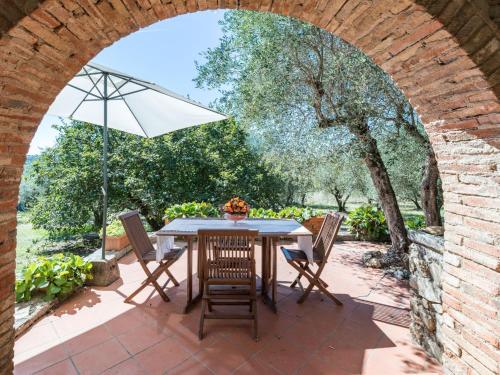an outdoor patio with a table with an umbrella at Apartment La Foresta-3 by Interhome in Quercegrossa