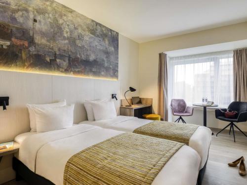 a hotel room with a large bed and a window at Mercure Oostende in Ostend