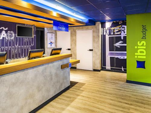 an office lobby with a reception counter with chairs at ibis budget SP Frei Caneca in Sao Paulo