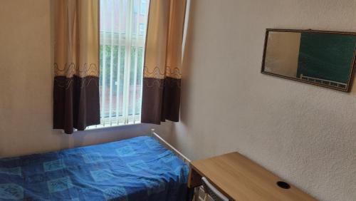 a bedroom with a bed and a chalkboard and a window at Edwardian House in Manchester