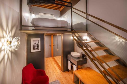 a room with a loft bed and a red chair at Cour des Loges Lyon, A Radisson Collection Hotel in Lyon