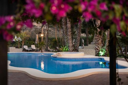una piscina en un complejo turístico con flores moradas en Hotel La Plantación, en Finestrat