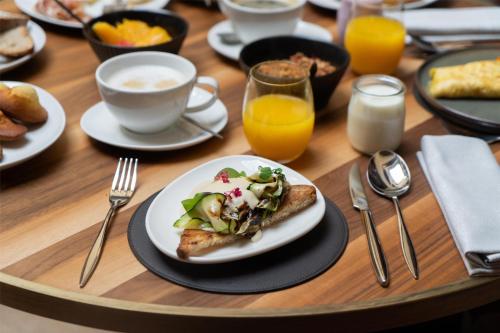 Una mesa con un plato de comida y una taza de café. en Cour des Loges Lyon, A Radisson Collection Hotel, en Lyon