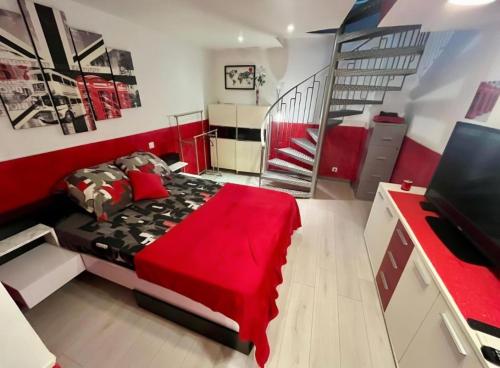 a bedroom with a red bed and a staircase at Le repaire d'Antibes atypique proche parc et mer in Juan-les-Pins