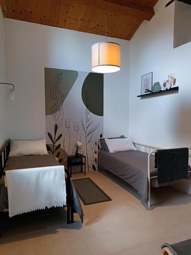 a bedroom with two beds and a pendant light at Casale di Maro in Monte Giberto