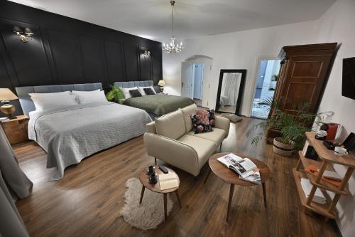 a bedroom with a bed and a couch and a chair at U Šuterů Boutique Hotel in Prague