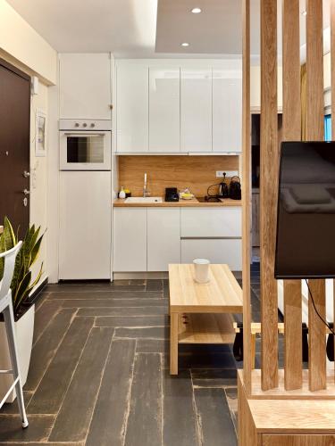 a kitchen with white cabinets and a wooden table at Ermou 18 Central Cozy Apartment in Athens