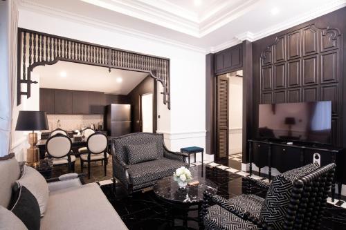 a living room with black and white furniture and a table at Perana Wellness Resort Chiang Mai in Ban Thung Pong