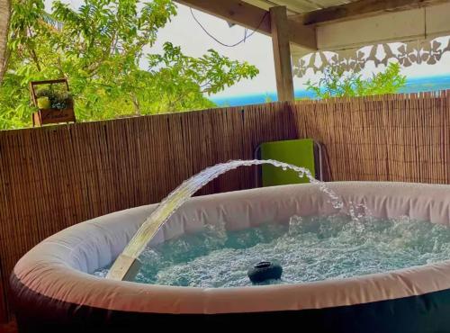 a pool of water in a circular bath tub at Maison de charme au Robert avec spa et vue sur mer in Le Robert