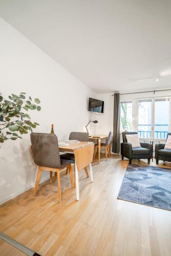 ein Wohnzimmer mit Tisch und Stühlen in der Unterkunft Modern Studio in the Heart of Linné, Walk to Haga in Göteborg