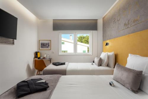 a hotel room with two beds and a window at Porta 30 in Oeiras