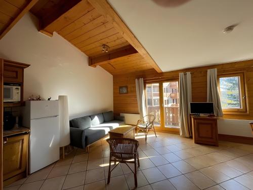 un salon avec un canapé et une cuisine dans l'établissement Appartement Les Airelles, à Levassaix