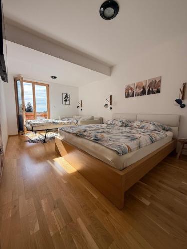a bedroom with a large bed and a wooden floor at Slunečný apartmán in Černý Dŭl
