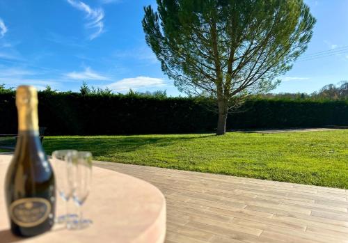 a bottle of wine sitting on a table with a glass at La Dolce Casa en M in Névy-lès-Dole