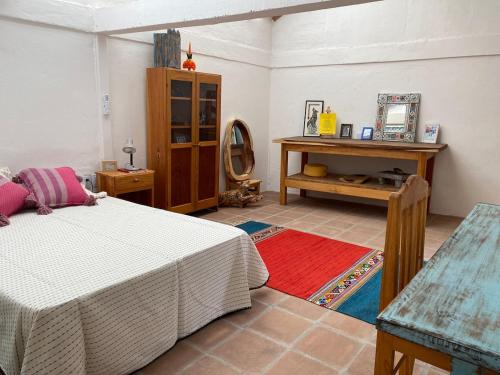 a bedroom with a bed and a table and a mirror at Casa Kata in Zipolite