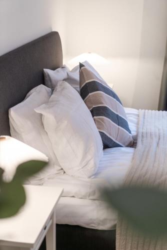 ein weißes Sofa mit Kissen darauf im Zimmer in der Unterkunft Warm Modern Studio in the Heart of Linné & Haga in Göteborg