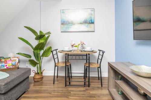 a table and chairs in a living room with a couch at Urban 1BR Gem with Kitchen, Smart TV & Workspace in Ottawa