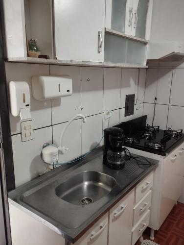 a small kitchen with a sink and a stove at Espaço Ideal 2 in Cascavel