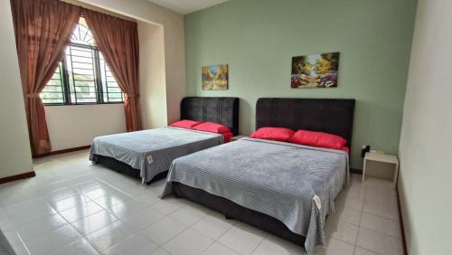 a bedroom with two beds and a window at Warisan Indah Homestay KLIA 2 Melayu sahaja in Sepang