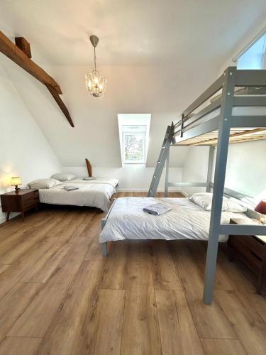 a bedroom with two bunk beds and a chandelier at Le Clos des Aulnes in Astillé