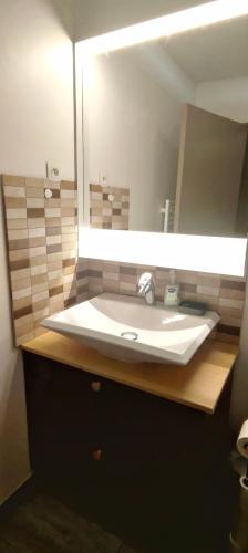 a bathroom with a sink and a large mirror at Entre Port historique et Calanques in La Ciotat