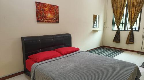 ein Schlafzimmer mit einem Bett mit roten Kissen darauf in der Unterkunft Warisan Indah Homestay KLIA 2 Melayu sahaja in Sepang