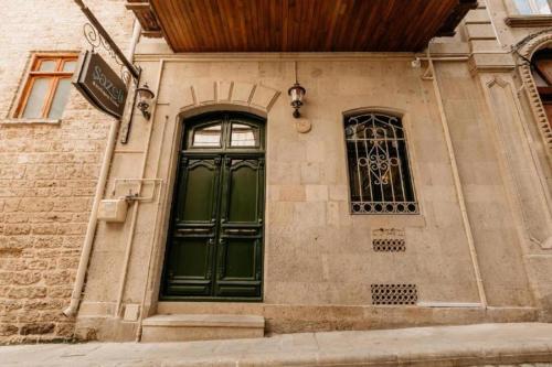 a green door on the side of a building at Sazeli Boutique Hotel in Baku