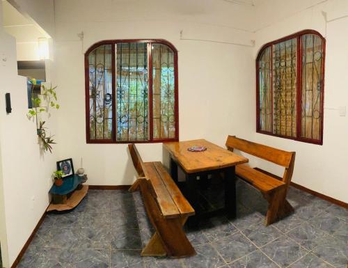 a room with a table and a bench and stained glass windows at Maudie in Santa Teresa Beach