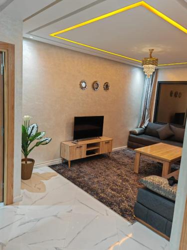 una sala de estar con un sofá y una mesa en Appartement idéal à El Jadida pour les familles, en Sidi Bouzid