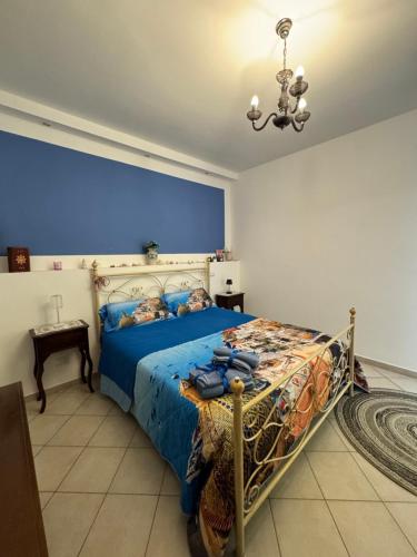 a bedroom with a bed and a chandelier at A mare,Pozzuoli-Licola in Licola