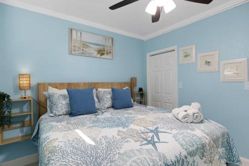 a bedroom with a bed with blue walls at Clearwater Beach Suites #102 in Clearwater Beach