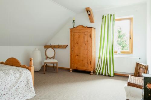 a bedroom with a bed and a dresser and a window at Idyllic Home Between Fields And Elbe Dyke in Seehausen