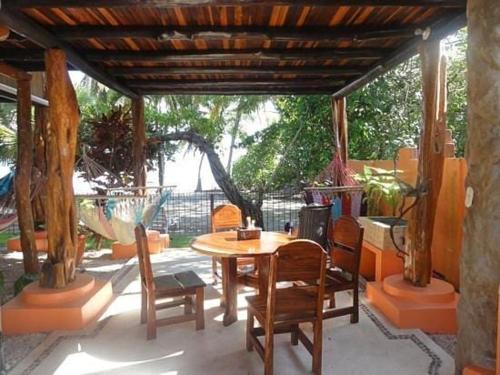 une table et des chaises en bois sur une terrasse dans l'établissement Samara Tree House Inn Unit 4, à Sámara