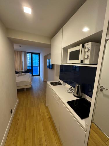 eine Küche mit weißen Schränken und einer Arbeitsplatte in der Unterkunft Orbi new batumi in Batumi