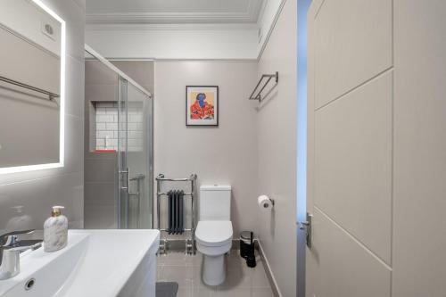 a white bathroom with a toilet and a sink at Zone 2 Luxury 3Bed 2Bath Apt - Kilburn in London