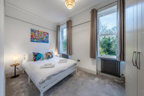 a bedroom with a white bed and a window at Zone 2 Luxury 3Bed 2Bath Apt - Kilburn in London