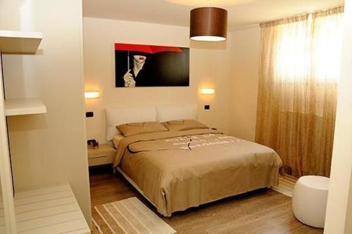 Un dormitorio con una cama y un cuadro en la pared. en Villa Panoramica, en Pozzolengo