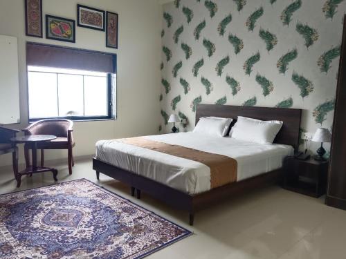Un dormitorio con una cama, un escritorio y una silla. en SHAURYAAKSH HOTEL & Home stay, en Jaipur