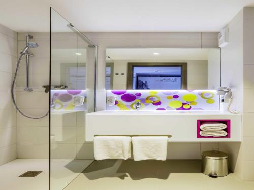 a bathroom with a shower and a mirror at ibis Styles Nowy Sacz in Nowy Sącz