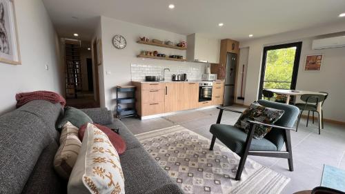 een woonkamer met een bank en een keuken bij Serena Terrace in Cabeceiras de Basto