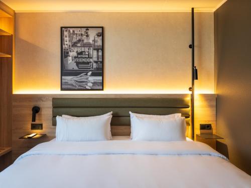 a bedroom with a large bed with two white pillows at Campanile Hotel & Restaurant Breda in Breda