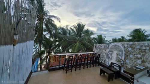 un grupo de bancos en un balcón con palmeras en Aurora Hostel Inn, en Boracay
