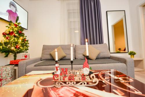 een woonkamer met een kerstboom en een tafel met kaarsen bij Bucharest Christmas Decorated City Center Villa in Boekarest