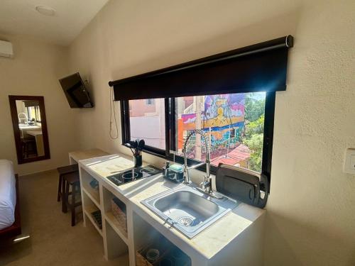 a bathroom with a sink and a window at The Mermaid and The Pearl Boutique Hotel in Isla Mujeres