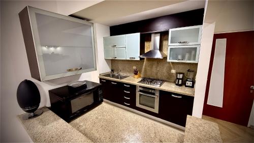 cocina pequeña con armarios blancos y fogones en Apartamento en Campo Alegre, Chacao, Caracas, en Caracas