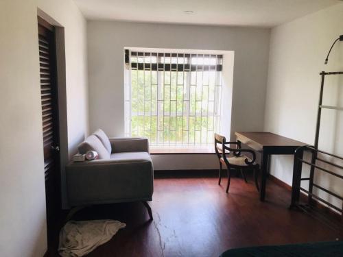 un salon avec un canapé, une table et une fenêtre dans l'établissement The Triantha, 