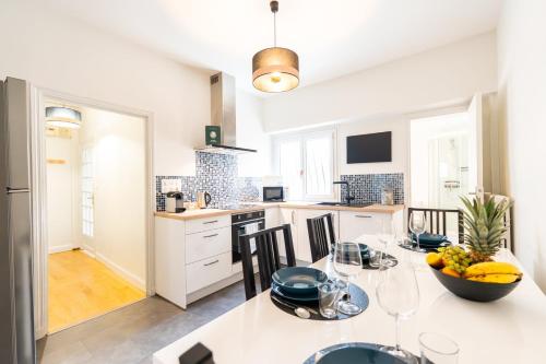 a kitchen with a table with a bowl of fruit on it at T2 chic et confortable au centre d Epernay in Épernay