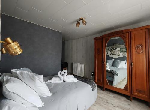 two swans sitting on a bed in a bedroom at Domaine Du Bouleau - Meublé T2 in Bains-les-Bains