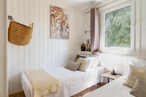 a white room with two beds and a window at Lodge Natura in Ambérieu-en-Bugey